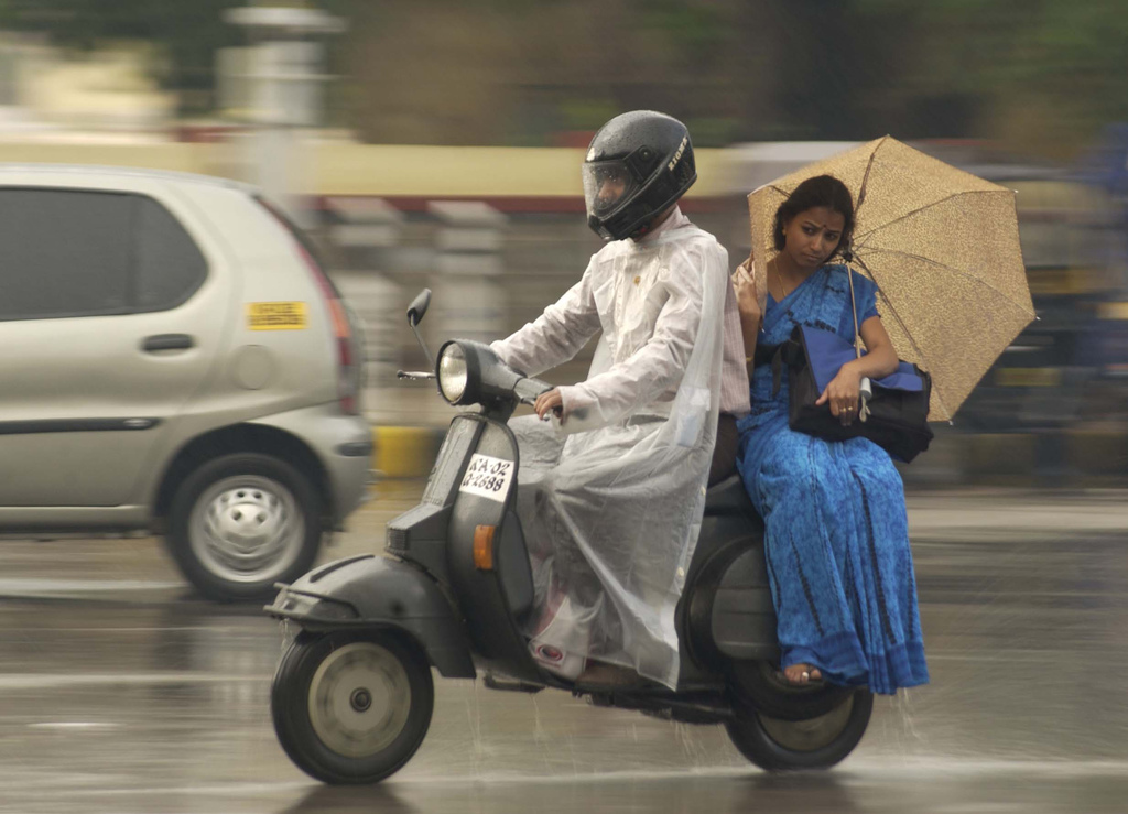 Motoristas circulando con lluvia